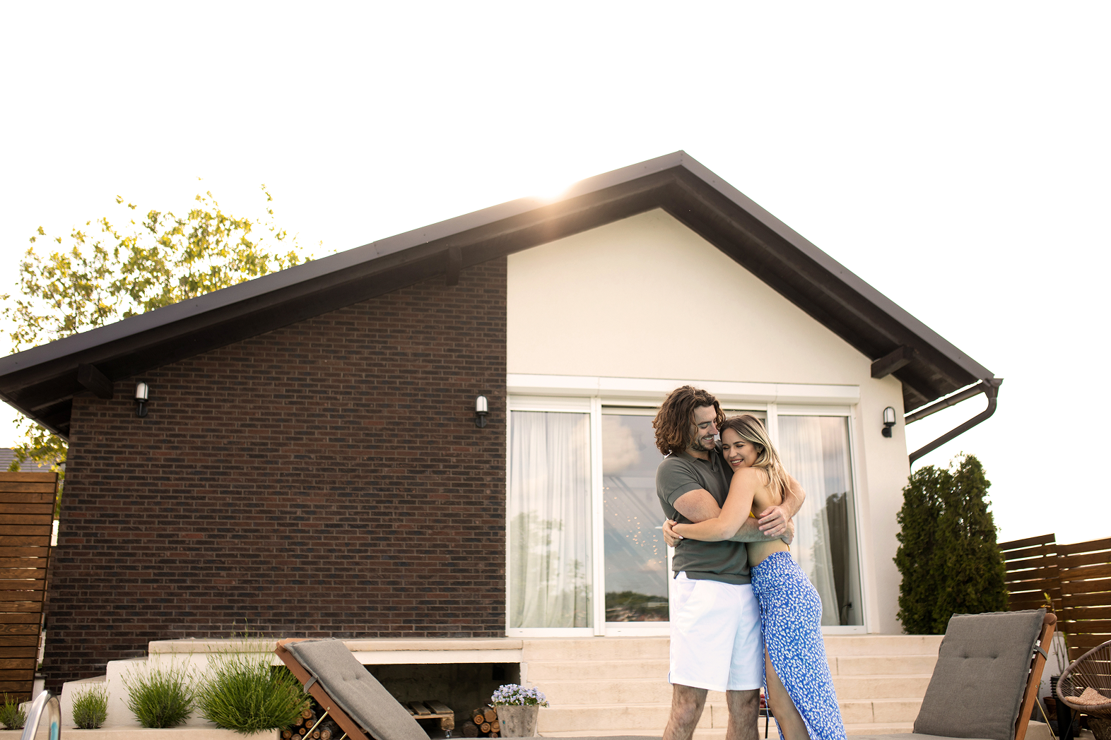 Couple hugging in front of their new house